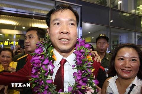Xạ thủ Hoàng Xuân Vinh được đông đảo người hâm mộ chào đón tại sân bay quốc tế Nội Bài. (Ảnh: Quốc Khánh/TTXVN)