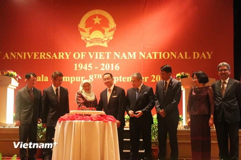 Đại sứ Việt Nam tại Malaysia Phạm Cao Phong và Bộ trưởng Văn phòng Chính phủ Malaysia Hajah Nancy Binti Shukri cắt bánh theo nghi lễ. (Ảnh: Hoàng Nhương/Vietnam+)