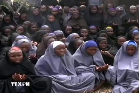 Các nữ sinh Nigeria bị Boko Haram bắt cóc trong trang phục Hồi giáo và đang làm lễ cầu nguyện tại một khu vực nông thôn không xác định được địa điểm ngày 12/5/2014. (Ảnh: AFP/TTXVN)