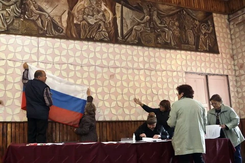 Treo cờ Nga tại một trạm bỏ phiếu trước cuộc bầu cử Duma quốc gia ở làng Gusino, phía tây nước Nga, ngày 17/9. (Nguồn: AP)