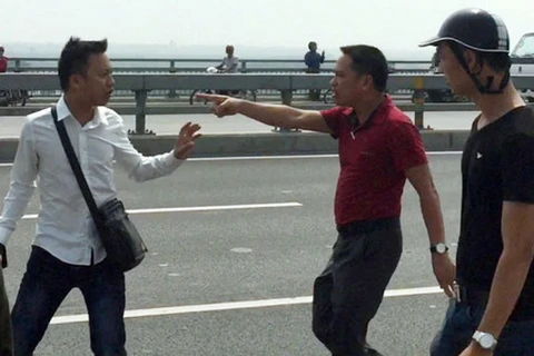 Nhà báo Quang Thế (áo trắng) bị hành hung khi đang tác nghiệp trên cầu Nhật Tân. (Nguồn:tuoitre.vn)