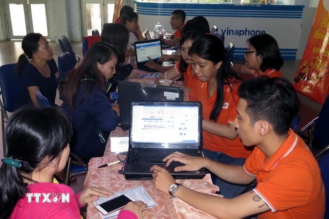 Nhân viên Công ty FPT hỗ trợ người dân truy cập Internet đặt mua vé tàu Tết Đinh Dậu 2017 tại ga Sài Gòn. )Ảnh: Hoàng Hải/TTXVN)