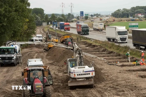 Các công nhân xây dựng tường chắn ở trại tị nạn gần Calais. (Ảnh: AFP/TTXVN)