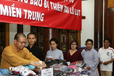 Bà con Phật tử đang quyên góp ủng hộ đồng bào miền Trung tại chùa Phật tích Vientiane. (Ảnh: Phạm Kiên/TTXVN)