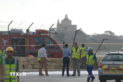 Lực lượng cứu hộ làm nhiệm vụ tại hiện trường vụ tai nạn máy bay. (Ảnh: AFP/TTXVN)