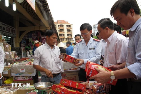 Đoàn Thanh tra Bộ Y tế và thanh tra liên ngành Thành phố Hồ Chí Minh kiểm tra bánh mứt nhân Tết Nguyên đán 2016 tại chợ Bình Tây. (Ảnh: Phương Vy/TTXVN)