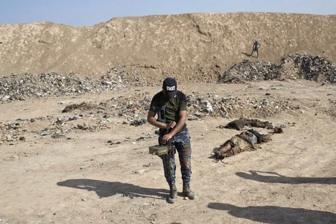 Nhân viên cảnh sát liên bang Iraq điều tra tại một ngôi mộ tập thể các nạn nhân bị IS sát hại ở Hamam al-Alil, cách Mosul khoảng 10km về phía nam ngày 11/11 vừa qua. (Ảnh: AP/TTXVN)
