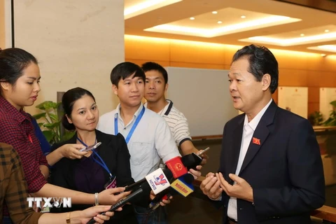Phóng viên phỏng vấn đại biểu Quốc hội bên lề một phiên họp của Kỳ họp thứ hai, Quốc hội khóa XIV. (Ảnh: Phương Hoa/TTXVN)