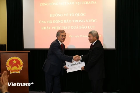 Đại sứ Việt Nam tại Ukraine Nguyễn Minh Trí (bên trái) tiếp nhận tiền quyên góp. (Ảnh:Dương Trí/Vietnam+)