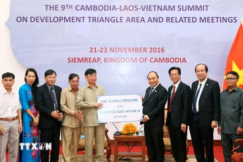Thủ tướng Nguyễn Xuân Phúc tặng bà con Việt kiều tại Siem Reap 5 tấn gạo. (Ảnh: Thống Nhất/TTXVN)