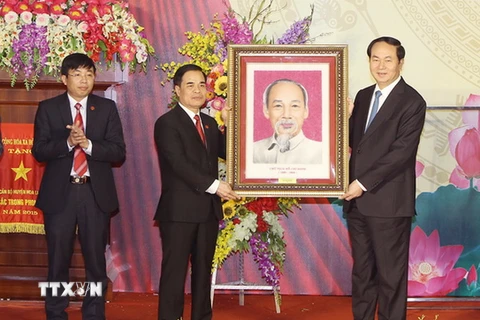Chủ tịch nước Trần Đại Quang tặng bức ảnh chân dung "Chủ tịch Hồ Chí Minh" cho Đảng bộ, chính quyền và nhân dân huyện Hoa Lư. (Ảnh: Nhan Sáng/TXVN)