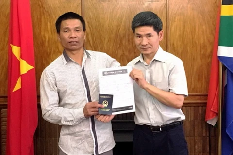 Đại diện Đại sứ quán trao vé máy bay và giấy thông hành cho anh Nguyễn Văn Thanh. (Nguồn: Đại sứ quán Việt Nam tại Nam Phi)