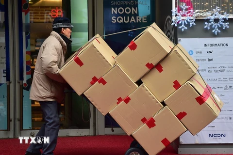 Người dân Hàn Quốc vận chuyển hàng hóa tại thủ đô Seoul. (Ảnh: AFP/TTXVN)