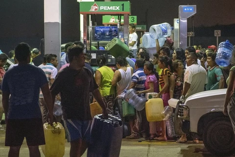Người dân ăn cắp xăng và dầu diesel từ một trạm xăng trong cuộc biểu tình ngày 3/1 vừa qua để chống lại việc tăng giá nhiên liệu của Mexico. (Nguồn: AP)