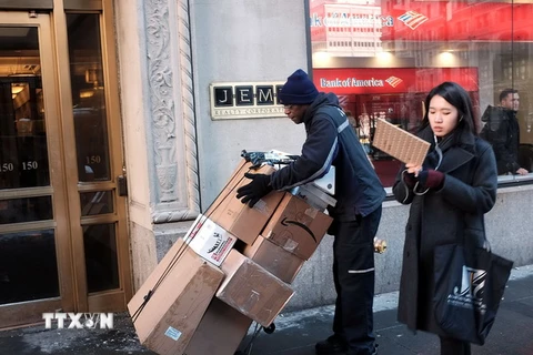 Người làm dịch vụ giao hàng tại Manhattan, thành phố New York, Mỹ. (Ảnh: AFP/TTXVN)