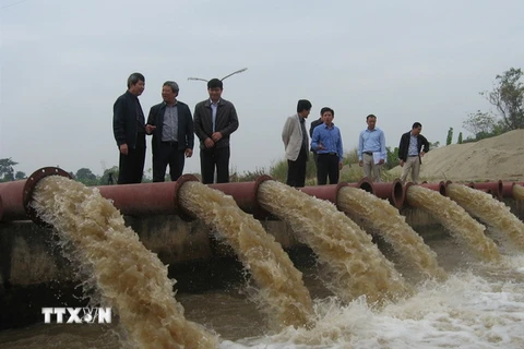 Lãnh đạo Sở Nông nghiệp và Phát triển Nông thôn Hà Nội kiểm tra lấy nước ở trạm bơm Ấp Bắc. (Ảnh: Đỗ Phương Anh/TTXVN)