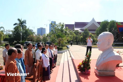 Các quan khách đang dành một phút mặc niệm trước bức Tượng bán thân của cố Chủ tịch Souphanouvong. (Ảnh: Phạm Kiên/Vietnam+)