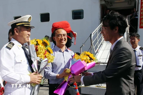 Đại diện lãnh đạo Sở Du lịch Đà Nẵng tặng hoa chúc mừng các du khách trên tàu Chinese Taishan đến xông đất Đà Nẵng. (Ảnh: Trần Lê Lâm/TTXVN)