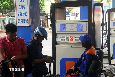 Khách hàng mua xăng tại cửa hàng kinh doanh xăng dầu trên phố Trần Hưng Đạo, quận Hoàn Kiếm, Hà Nội. (Ảnh: Quang Quyết/TTXVN)