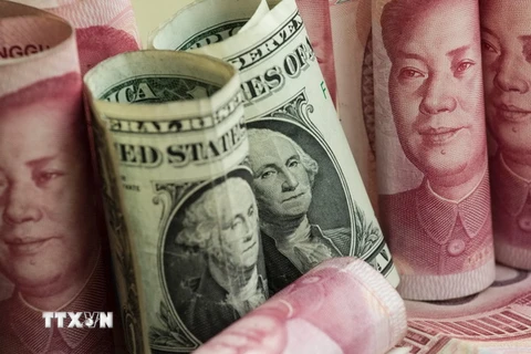 Tiền giấy mệnh giá 100 nhân dân tệ của Trung Quốc và đồng USD. (Ảnh: AFP/TTXVN)