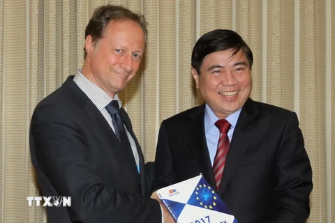 Đại sứ Bruno Angelet tặng sách trắng cho Chủ tịch UBND TP Hồ Chí Minh Nguyễn Thành Phong. (Ảnh: Thanh Vũ/TTXVN)