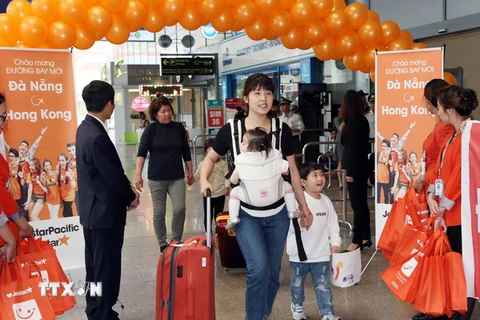 Những vị khách đầu tiên trên đường bay mới từ Hồng Kông đến Đà Nẵng. (Ảnh: Trần Lê Lâm/TTXVN)