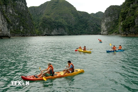Du khách bơi thuyền Kayak trên Vịnh Hạ Long. (Ảnh: Tiến Dũng/TTXVN) 