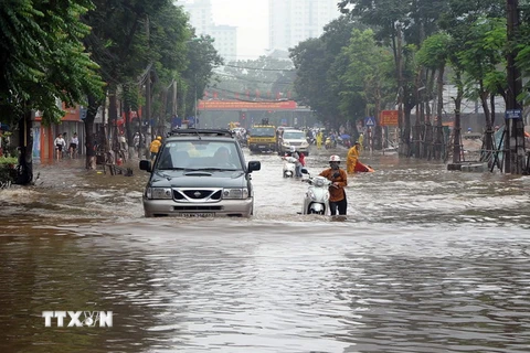 Mưa lớn gây ngập sâu tại khu vực đường Thái Hà mới ở quận Đống Đa gây ảnh hưởng đến đến việc đi lại của người dân. (Ảnh: Quang Quyết/TTXVN)