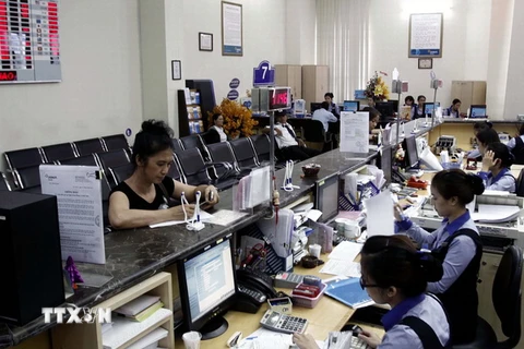 Khách hàng đến giao dịch tại Hội sở DongA Bank tại thành phố Hồ Chí Minh. (Ảnh: Hoàng Hải/TTXVN)