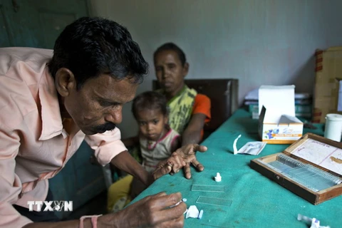 Nhân viên y tế lấy máu xét nghiệm từ bệnh nhân sốt rét tại Gauhati, Ấn Độ. (Ảnh: AP/TTXVN)