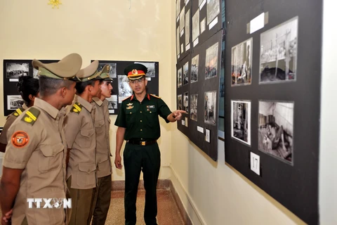 Tùy viên Quốc phòng Việt Nam tại Cuba Vũ Thế Trung giới thiệu các tác phẩm ảnh trưng bày tại triển lãm. (Ảnh: Vũ Lê Hà/TTXVN) 