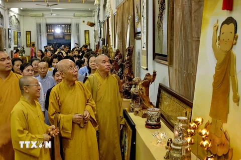 Các Chư tôn giáo phẩm cùng đông đảo phật tử tham quan triển lãm văn hóa nghệ thuật Phật giáo với hơn 500 tác phẩm từ tranh ảnh, tượng và sản phẩm điêu khắc tại tuần lễ văn hóa. (Ảnh: Thế Anh/TTXVN)