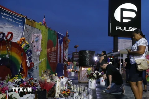 Người dân Mỹ đặt hoa tưởng niệm các nạn nhân của vụ tấn công tại hộp đêm Pulse ở Orlando, Florida ngày 11/6. (Ảnh: AFP/TTXVN)