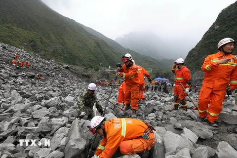 Lực lượng cứu hộ nỗ lực tìm kiếm các nạn nhân mất tích sau thảm họa lở núi ở huyện Mậu ngày 24/6. (Ảnh: THX/TTXVN)