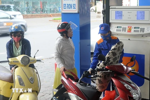 Khách hàng mua xăng tại cửa hàng kinh doanh xăng dầu trên phố Trần Hưng Đạo, quận Hoàn Kiếm, Hà Nội. (Ảnh: Quang Quyết/TTXVN)