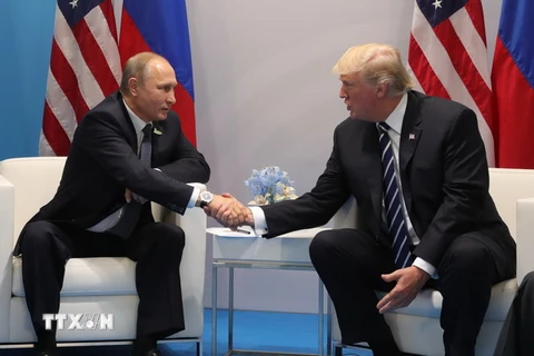 Tổng thống Nga Vladimir Putin và Tổng thống Mỹ Donald Trump trong cuộc gặp đầu tiên. (Ảnh: AFP/TTXVN)