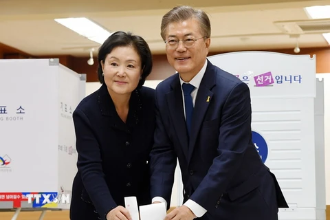 Ứng cử viên Moon Jae-in (phải) và vợ bỏ phiếu tại một địa điểm bầu cử ở Seoul. (Ảnh: Yonhap/TTXVN)