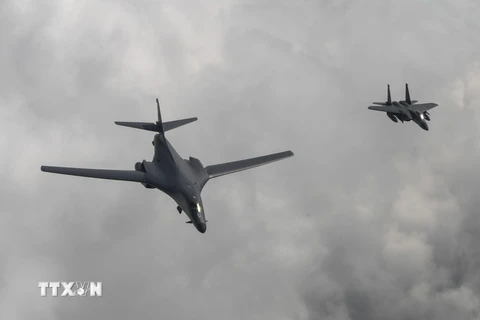 Máy bay ném bom B1-B của Mỹ (trái) thực hiện hành trình bay 10 giờ từ Căn cứ không quân Andersen, đảo Guam đến bán đảo Triều Tiên ngày 30/7 vừa qua. (Ảnh: EPA/TTXVN)