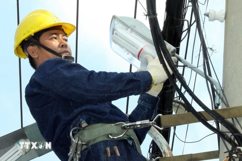 Công nhân ngành điện TP Hồ Chí Minh thực hiện công trình nguồn sáng an toàn, văn minh và tiết kiệm. (Ảnh: Thanh Vũ/TTXVN)