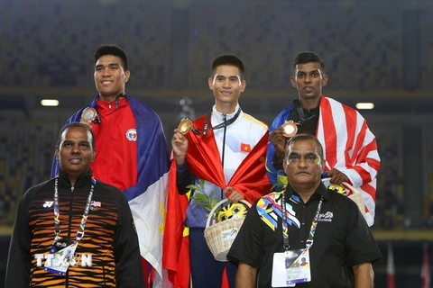 Vận động viên Dương Văn Thái (giữa) nhận huy chương vàng. (Ảnh: Quốc Khánh/TTXVN)