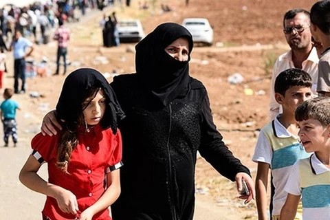 Những người tị nạn Syria đến cửa khẩu qua Oncupınar, gần thị trấn Kilis, miền nam Thổ Nhĩ Kỳ, để vượt biên đến Syria. (Nguồn: AFP)