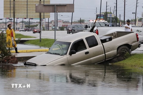 Ôtô bị nước lũ cuốn trôi trong bão Harvey tại Mỹ ngày 27/8. (Ảnh: EPA/TTXVN)
