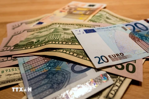 Đồng euro và đồng USD. (Ảnh: AFP/TTXVN)