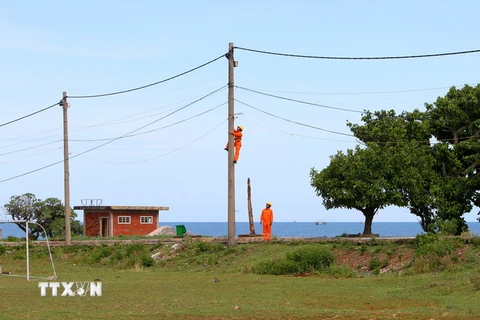 Sửa chữa lưới điện hạ thế trên đảo. (Ảnh: Ngọc Hà/TTXVN)
