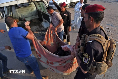 Lực lượng an ninh Iraq chuyển thi thể nạn nhân tại hiện trường vụ tấn công ở Nasriyah ngày 14/9 vừa qua. (Ảnh: AFP/TTXVN)