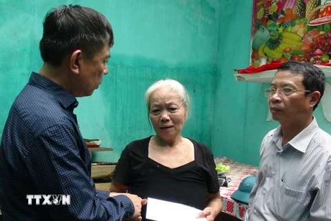 Chủ tịch UBND tỉnh Quảng Bình Nguyễn Hữu Hoài (trái) thăm động viên một hộ gia đình ở thị trấn Đồng Lê, huyện Tuyên Hóa, bị sập nhà do bão số 10. (Ảnh: Đức Thọ/TTXVN)