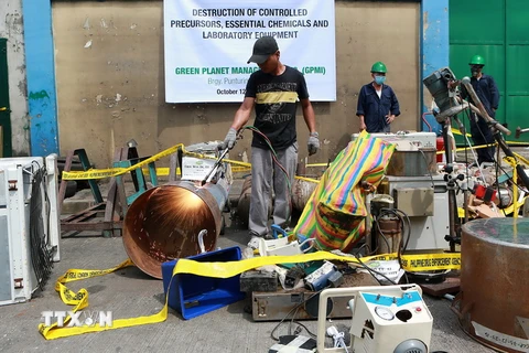 Nhân viên Cơ quan Chống Ma túy Philippine (PDEA) tiêu hủy dụng cụ và hóa chất tại một cơ sở điều chế ma túy trái phép ở thành phố Valenzuela, Philippines, ngày 12/10 vừa qua. (Ảnh: THX/TTXVN)
