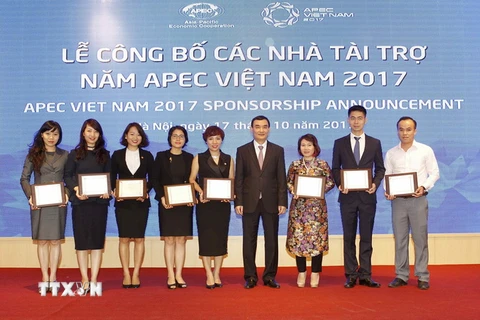 Ông Nguyễn Xuân Thành, Phó Chủ nhiệm Văn phòng Chính phủ, Trưởng Ban Vận động tài trợ - Ủy ban Quốc gia APEC trao Kỷ niệm chương cho các nhà tài trợ. (Ảnh: Văn Điệp/TTXVN)