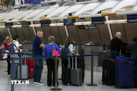 Hành khách làm thủ tục tại quầy của hãng hàng không Air France ở sân bay quốc tế John F. Kennedy, New York, Mỹ. (Ảnh: AFP/TTXVN)