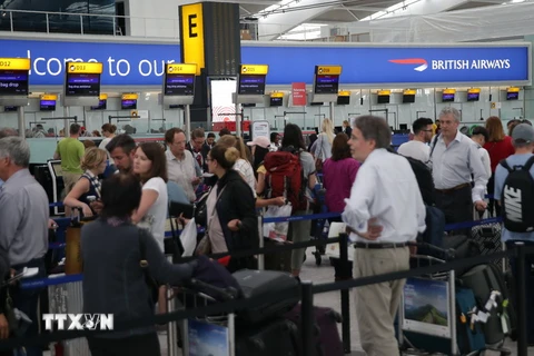 Hành khách chờ làm thủ tục tại sân bay Heathrow ở London. (Ảnh: AFP/TTXVN)